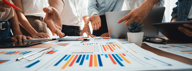 Leinwandbilder - Focus panorama shot of chart and graph paper with blur analyst team utilize BI Fintech to analyze financial dashboard, brainstorm and analyzing report paper on table for business insight. Scrutinize
