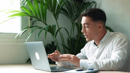 Wall Mural - Concentrated skilled millennial caucasian businessman in glasses wearing headphones with mic, taking part in online web camera negotiations meeting using computer app, distant communication concept.
