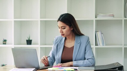 Wall Mural - Businesswoman Sitting at Desk Working on Laptop Computer in modern Office.