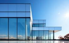 Graphite Facade And Large Windows On A Fragment Of An Office Building Against A Blue Sky