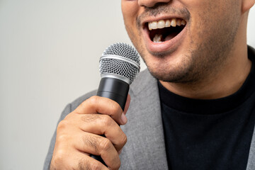 Canvas Print - Close up businessman speaker hand holding High quality dynamic microphone and singing song or speaking talking with people on isolated white background. Male testing microphone voice for interview