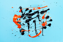 Orange And Black Oil Paints Splashed In Disorder On Center Of Blue Surface 