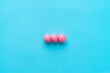 © Clique Images - High angle view of three bright pink eggs prepared for Easter celebration lying on center of turquoise surface