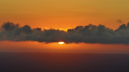 Wall Mural - Bright sunset with setting sun behind vivid orange and yellow clouds