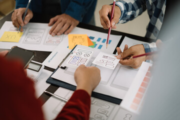 ui designer brainstorming about mobile app interface wireframe design with customer breif and color code at office.