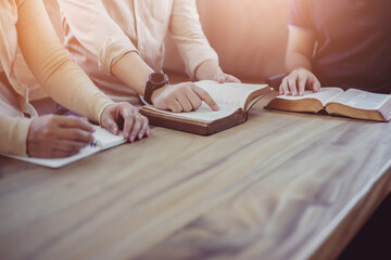 close up of christian group hold and opening bible page while reading and study bible together with 