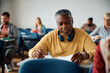 © Drazen - Black senior student writing an exam in lecture hall.