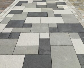 Pavement made of black, white and gray concrete tiles for outdoors. Background and texture.