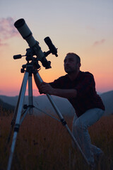 Wall Mural - astronomer looking at the skies with a telescope.