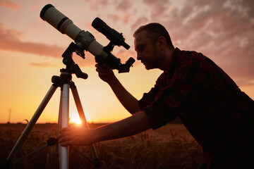Wall Mural - astronomer looking at sky with a telescope.