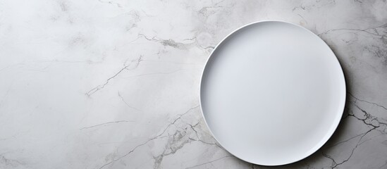 Aufkleber - A white plate is placed on a white stone table, viewed from the top, with empty space around it.