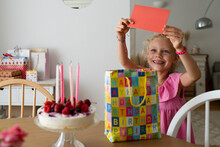 Smiling Girl Holding Birthday Card At Home