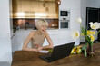 © Westend61 - Happy nutritionist taking notes of diet from laptop at home
