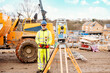 © Iryna - Surveyor builder site engineer with theodolite total station at construction site outdoors during surveying work
