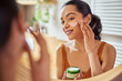 Woman applying face cream during morning routine