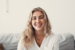 © Daniel - Close up overjoyed woman laughing, sitting on couch at home, head shot portrait young female chatting online with friends or relatives, looking at camera, having fun, making call or shooting video.