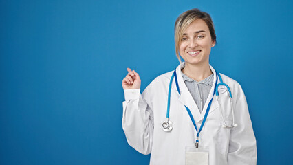 Poster - Young blonde woman doctor smiling pointing to the side over isolated blue background