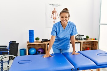 Canvas Print - Young beautiful hispanic woman physiotherapist smiling confident standing at rehab clinic