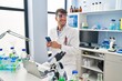 © Krakenimages.com - Young hispanic man scientist smiling confident using smartphone at laboratory