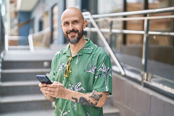 Sticker - Young bald man smiling confident using smartphone at street