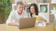 © Krakenimages.com - Senior man and woman couple using laptop drinking coffee at dinning room