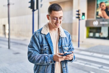 Canvas Print - Young hispanic man smiling confident using smartphone at street