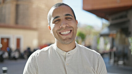 Wall Mural - Young hispanic man smiling confident at street