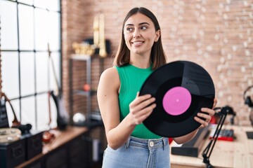 Poster - Young hispanic woman musician holding vinyl disc at music studio