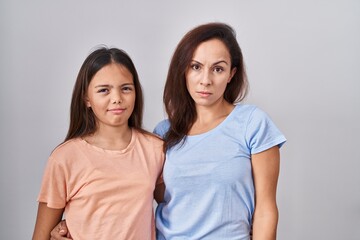 Canvas Print - Young mother and daughter standing over white background skeptic and nervous, frowning upset because of problem. negative person.