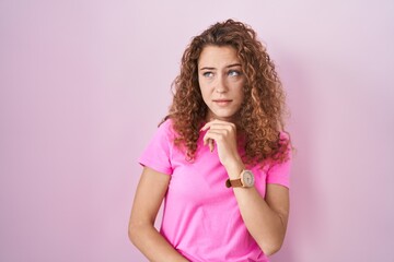 Sticker - Young caucasian woman standing over pink background thinking worried about a question, concerned and nervous with hand on chin