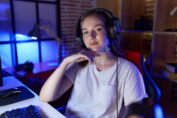 Poster - Young caucasian woman streamer smiling confident sitting on table at gaming room