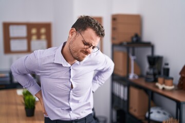 Sticker - Young hispanic man at the office suffering of backache, touching back with hand, muscular pain