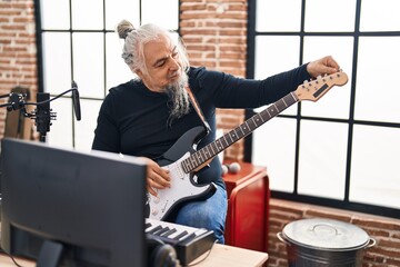 Sticker - Middle age grey-haired man musician smiling confident playing electrical guitar at music studio