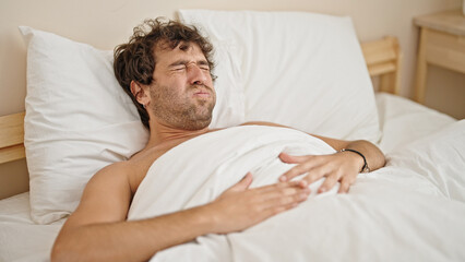 Sticker - Young hispanic man suffering for stomach ache lying on bed shirtless at bedroom