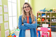 © Krakenimages.com - Young caucasian woman working as teacher at kindergarten happy face smiling with crossed arms looking at the camera. positive person.