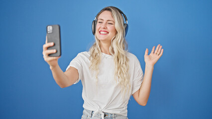 Poster - Young blonde woman smiling confident having video call over isolated blue background