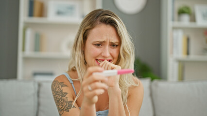 Canvas Print - Young blonde woman waiting for pregnancy result test nervous at home