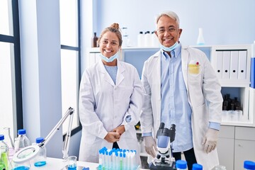 Poster - Middle age hispanic people working at scientist laboratory with a happy and cool smile on face. lucky person.