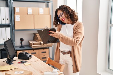 Middle age hispanic woman working speaking on the phone at ecommerce