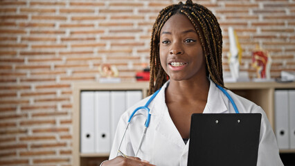 Wall Mural - African american woman doctor holding medical report speaking at the clinic