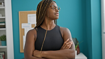 Wall Mural - African american woman business worker standing with arms crossed gesture and serious face at the office