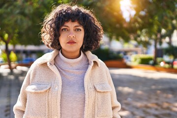 Wall Mural - Young beautiful hispanic woman standing with serious expression at park