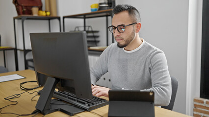 Poster - Hispanic man business worker using computer and tablet at office