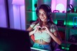 © Krakenimages.com - Young beautiful hispanic woman streamer smiling confident doing heart symbol with hands at gaming room