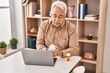 © Krakenimages.com - Senior man using laptop holding pills at home
