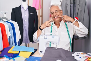 Canvas Print - Middle age man with grey hair dressmaker using sewing machine smiling cheerful showing and pointing with fingers teeth and mouth. dental health concept.