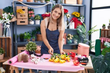 Canvas Print - Young caucasian woman florist make bouquet of flowers at florist