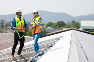 electrical engineering team man and woman worker Installing Solar Cell panels on Roof. Solar energy clean and green alternative energy. Unity and teamwork