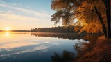 Fototapeta Natura - Sunshine over orange foliage on a riverside in autumn landscape of Belarus or Europe at sunrise