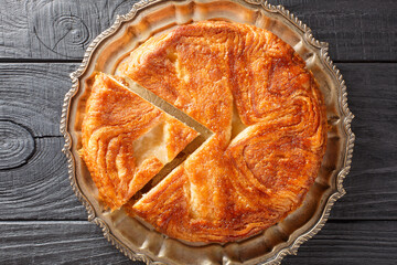 Canvas Print - Kouign Amann is a pastry made with a lot of butter from the Brittany region of France closeup on the plate on the table. Horizontal top view from above